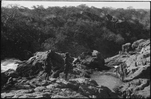 Two men standing next to rapids at Ruacana Falls