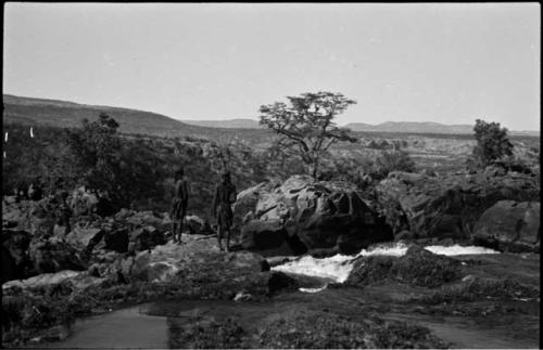 Two men standing on the rocks at the top of Ruacana Falls