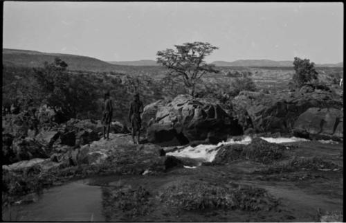 Two men standing on the rocks at the top of Ruacana Falls