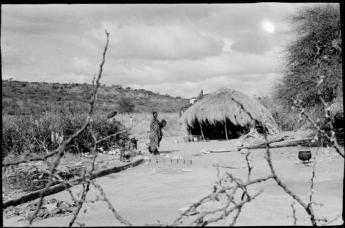 Woman standing outside of a hut