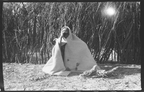 Elderly woman sitting wrapped in a kaross