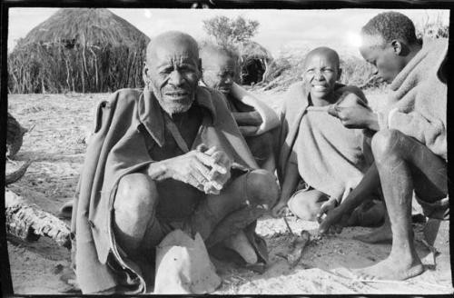 Elderly blind man sitting with three other people