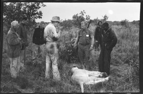 Theunis Berger and six other people standing around a dead lion