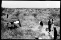 Five people standing in the camp with Elizabeth Marshall Thomas standing in the distance