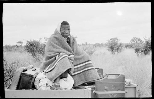 Dabe wrapped in a blanket sitting on top of a truck