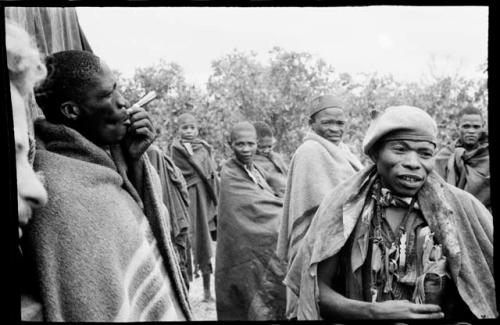 Group of men, one smoking, next to the truck