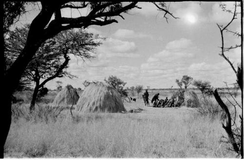 Group sitting between two huts