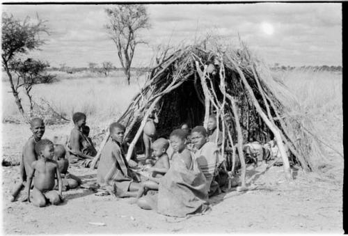 Group sitting in front of a grass hut at Kungwane
