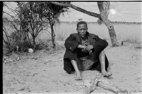 Man in a black overcoat sitting