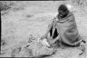 Man sitting with a kaross full of millet