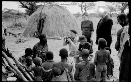 John Marshall photographing a seated group at Kungwane; Elizabeth Marshall Thomas and Lorna Marshall next to him