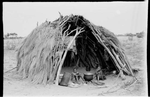 Two boys sitting in a hut at Chukudu