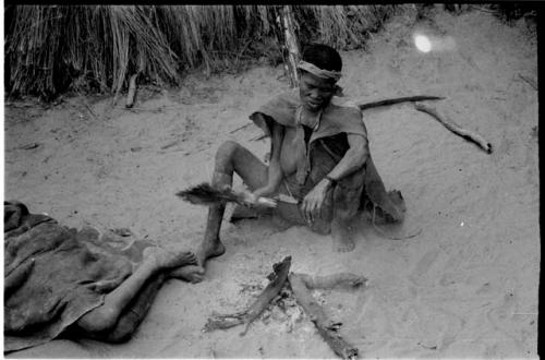 Woman fanning a fire with feathers