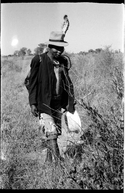 Man wearing a feather in his hat, walking