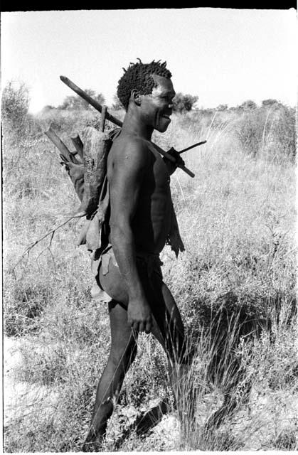 Man carrying a stick on his shoulder and on his back