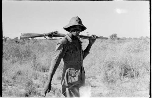 Headman carrying a gun over his shoulder