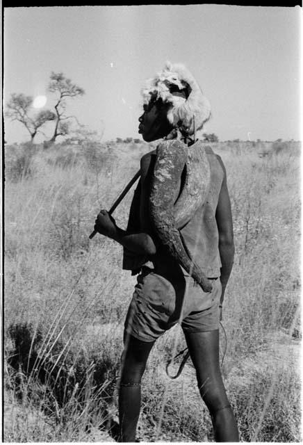 Man with a fur cap and two large horns on his back