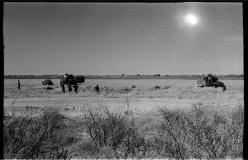 Expedition members and trucks around !Kusi Pan, more distant