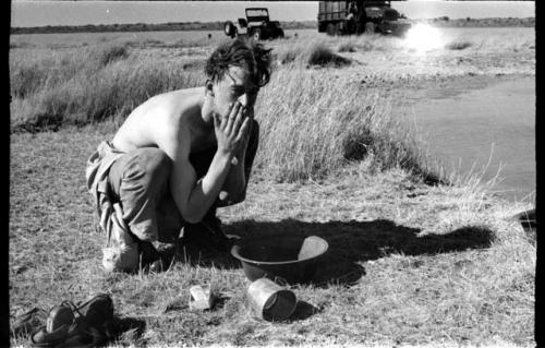 John Marshall washing his face from a bowl at !Kusi Pan