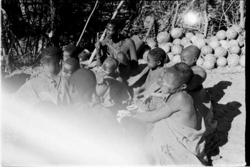 Group sitting with tsama melons in the background