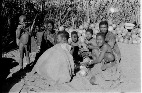 Group sitting by a pile of tsama melons