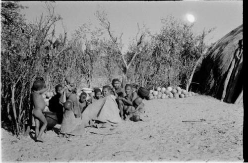 Group sitting by a pile of tsama melons