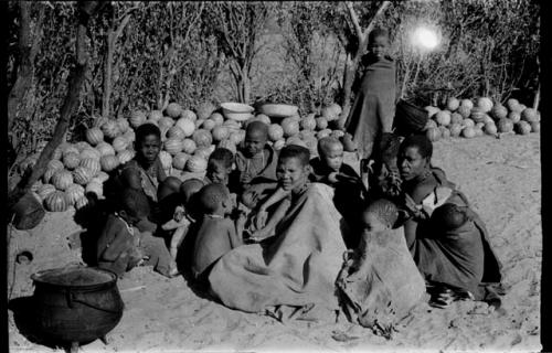 Group sitting by a pile of tsama melons