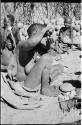 Woman squeezing a handful of pulp from the water root up to her mouth to drink