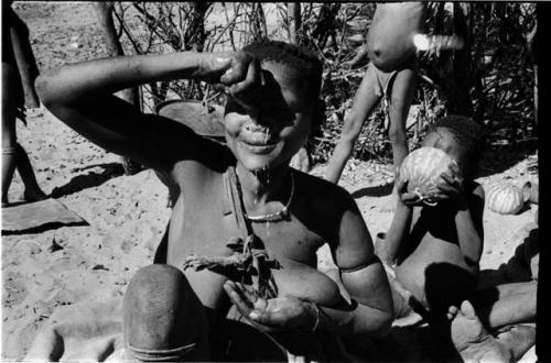 Woman squeezing a handful of pulp from the water root over her face to wash