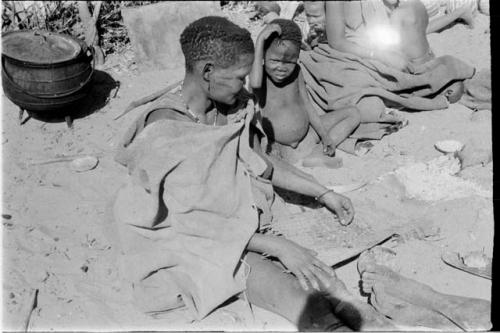 Woman sieving ashes from tsama melon seeds