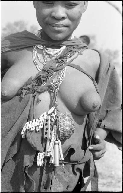 Close-up of woman's chest showing tortoise shell and bead ornaments