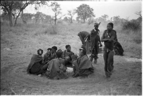 Three men, including /Gunda and ≠Gao, dancing around a group of seated women singing; medicine man leaning over "Gao Medicine" far back behind