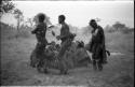 Three men, including /Gunda and ≠Gao, dancing around a group of seated women singing; medicine man leaning over "Gao Medicine" far back behind