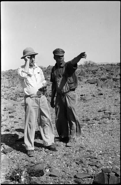 Two men standing and looking at something in the distance