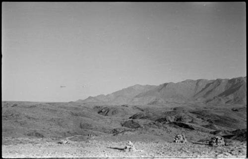 Small piles of rocks, with hills and mountains in background