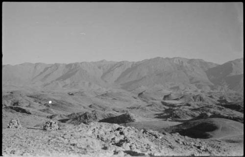 Small piles of rocks, with hills and mountains in background