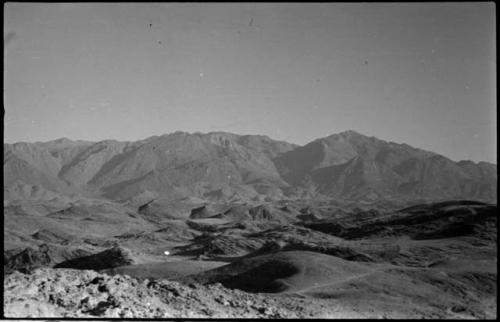 Small piles of rocks, with hills and mountains in background