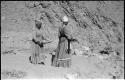 Two women standing and mining by panning