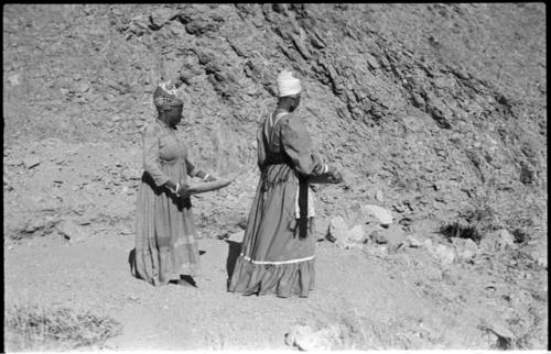 Two women standing and mining by panning