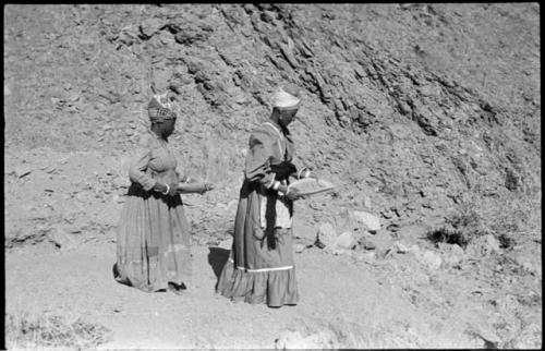 Two women standing and mining by panning