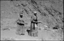 Two women standing and mining by panning