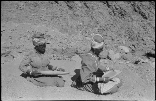 Two women sitting and mining by panning