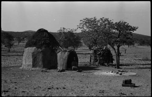 Woman sitting in the doorway of a hut