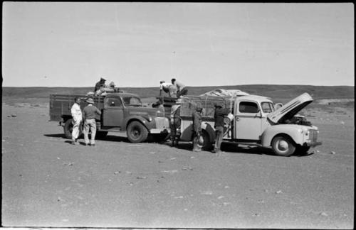 Expedition members standing next to trucks