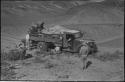 Expedition members putting brush under wheels of truck and retrieving something from the load