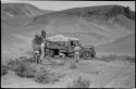 Expedition members putting brush under wheels of truck and retrieving something from the load