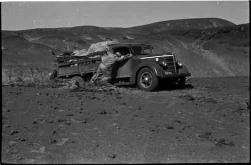 Expedition members pushing a truck out of the sand