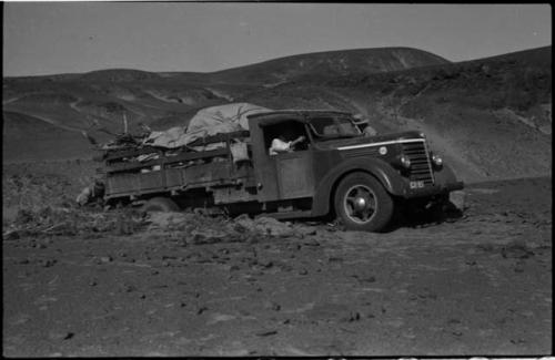 Expedition members pushing and driving a truck out of the sand