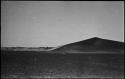 Dune, with three abandoned huts in the distance