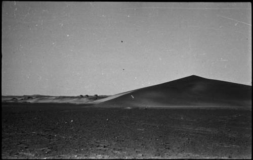 Dune, with three abandoned huts in the distance